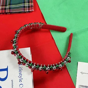 Close-up detail of Christmas red velvet headband decorated with colorful jingle bells.