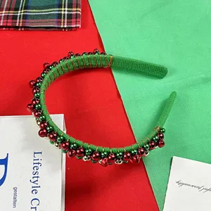 Christmas green headband detail showing red and green bells wrapped in soft flannel fabric.