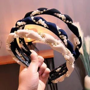 Vista dettagliata di cerchietti intrecciati di perle con design intrecciato, accessori capelli donna.