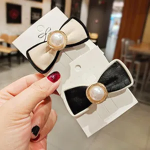 Elegant bow hair clips with pearl centerpiece, stylish hair accessories for women and girls.