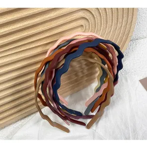 Closeup details of colorful matte wavy plastic hair hoop, anti-slip design for women daily use.