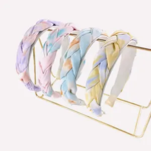 Vue détaillée de serre-têtes tressés colorés avec motif tie-dye et texture de nœud.