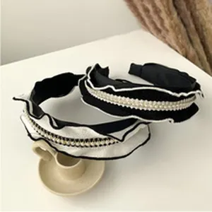Chic wide fabric headband for women featuring elegant ruffles and faux pearl decor.