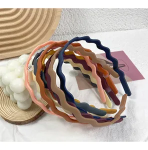 Close-up detail shot of assorted colorful wavy matte plastic headbands featuring anti-slip design.