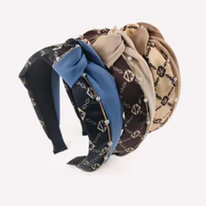 Bandeau noué élégant avec perles et motif de chaîne géométrique chic pour les femmes.