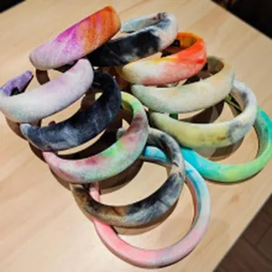 Detailed shot of multi-color tie-dye wide plush headbands, soft texture and retro style.