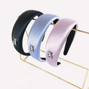 Detailed view of wide fashion headbands with crystal bear charms, elegant hair accessories.