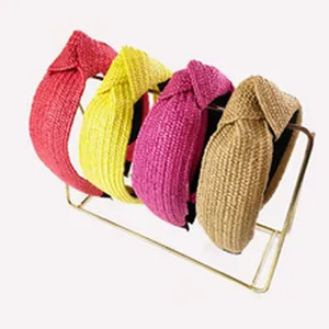 Vue détaillée de serre-têtes noués en raphia tissé de différentes couleurs sur support.