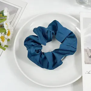 Detail view of dark blue fabric hair scrunchie, soft scrunch design, elegant daily hair accessory.