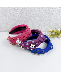 Close-up detail of colorful knotted fabric headbands with sparkling rhinestones and sports charms.