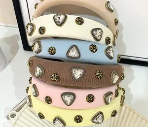 Detailed close-up view of chic wide fabric headbands with sparkling rhinestones and metal accents.