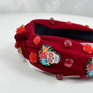 Red velvet knotted headband with festive colorful skull and rhinestone details for women.