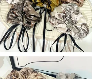 Detailed view of vintage floral scrunchies with rhinestone buckle and long black ribbons.