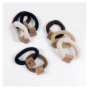 Detailed shot of cute bear hair ties, minimalist brown elastic hair ropes for daily ponytails.
