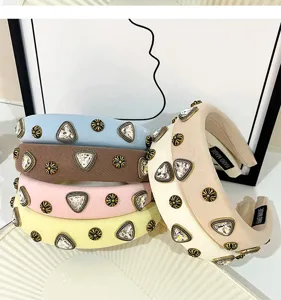 Close-up detail of wide fabric rhinestone hairbands featuring vintage metal crystal studs.