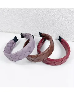 Handmade braided wide leather headband detail shot, stylish twist hair hoop accessories.
