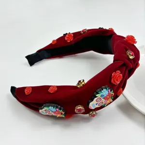 Red velvet knotted headband featuring red roses rhinestones and Halloween skull details for parties.