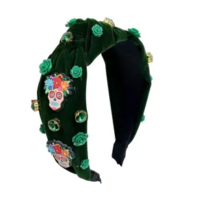 Dark green velvet headband detailed with sparkling rhinestones, green roses and skull decor.