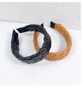 Detailed view of handmade woven leather hairbands in black and brown, chic braided design.