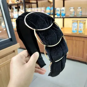 Black velvet headband featuring intertwined gold metal rings, trendy hair accessory.