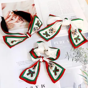 Detailed shot of red green striped hair accessories set featuring cute cat print and bows.