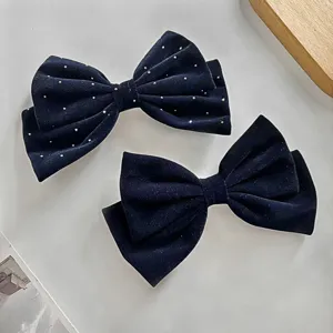 Détail de pince à cheveux nœud en velours, avec strass et tissu doux pour des coiffures élégantes.