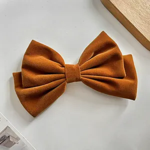 Barrette nœud en velours marron, texture douce et design multicouche élégant pour coiffures.
