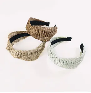Vue détaillée de serre-têtes croisés en paille tressée style bohème aux couleurs chic.