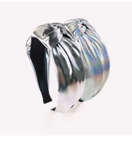 Shiny metallic knotted headband detail closeup view, fashion wide hair accessory for women.