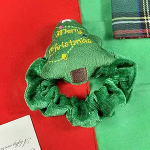 Vista dettaglio scrunchie peluche albero di natale, accessorio capelli elastico velluto.