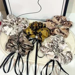 Elegant floral satin hair scrunchies with long ribbons and crystal charms for women daily.