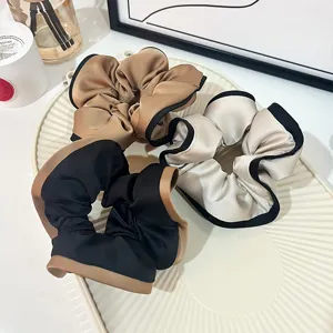 Elegant satin hair scrunchies with contrast border, stylish vintage ponytail hair accessories.
