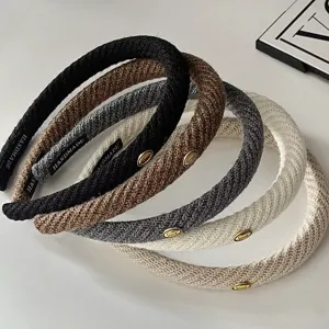 Detailed shot of trendy knitted textured headbands with metal love decor for women fashion.
