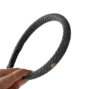 Dark gray knitted headband featuring chevron texture and metal love accent for autumn and winter.
