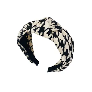 Classic black and white houndstooth fabric headband with a stylish knotted design for women.