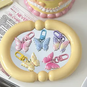 Close-up detail of colorful butterfly keychains showcased on a vintage mirror tray.