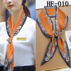 Detailed view of the narrow floral silk scarf with elegant orange and grey design.