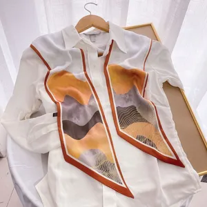 Detailed view of women's white long-sleeve blouse with stylish abstract printed scarf ribbon.