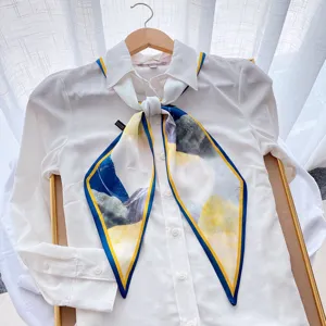 Chic narrow silk scarf detail showcasing abstract geometric print and elegant blue yellow tones.