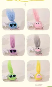 Dettaglio molletta per capelli troll in peluche, soffici palline colorate con occhi e occhiali.