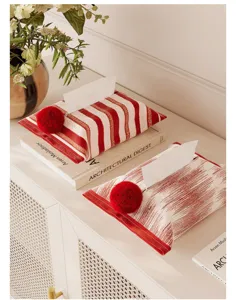 Modern fabric tissue box cover featuring red white stripes and cute pom-pom decor for home.