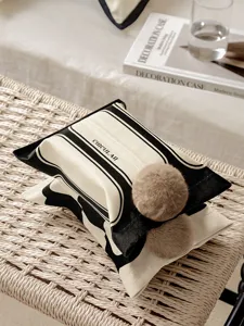 Chic black and white fabric tissue box cover with fluffy pom pom balls for home decor.