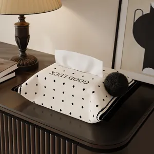 Knitted tissue box cover with diamond pattern and black pom-pom for home desktop decor.
