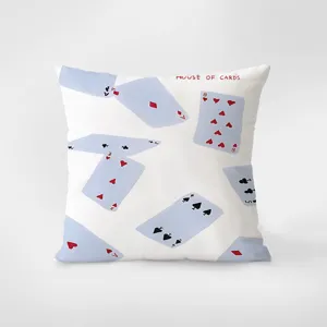 Detalle de cojín decorativo con estampado de naipes en tonos azules calmados y diseño.