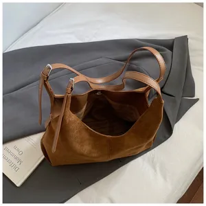 Detailed view of brown suede shoulder bag, showing soft texture, spacious interior and straps.