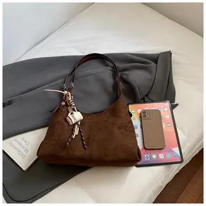 Brown suede shoulder bag for women, stylish hobo underarm handbag with chic charm accessory.
