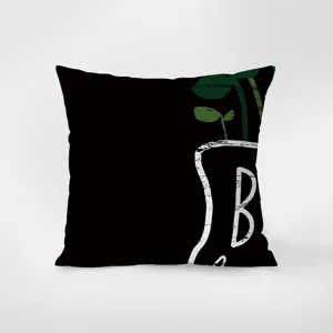 Dettaglio in primo piano di cuscino in velluto nero con illustrazione di pianta.