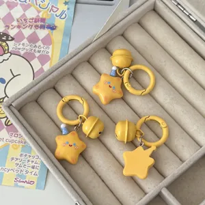Detailed close-up view of cute yellow star keychains with mini hats and bells inside jewelry box.