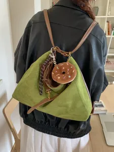 Stylish vintage green suede multi-way shoulder bag with cute donut charm and brown straps.