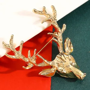 Gros plan d'une broche tête de cerf dorée avec andouillers détaillés, élégant bijou de mode.